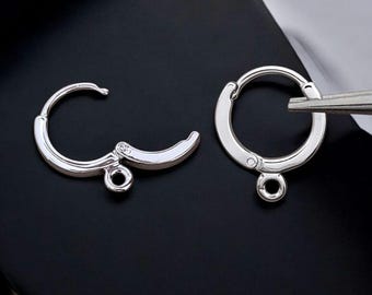 May include: Two silver earring hooks with a small loop at the bottom. The hooks are open and ready to be attached to earrings.