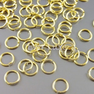 May include: A large quantity of gold jump rings. The jump rings are small and circular, and they are perfect for jewelry making.