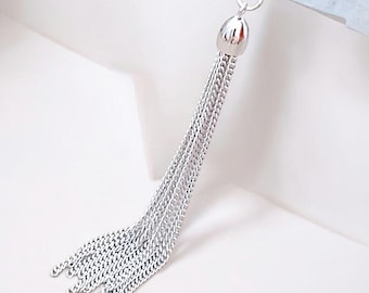 May include: A silver chain tassel with a round, textured top. The tassel is made of multiple strands of chain.