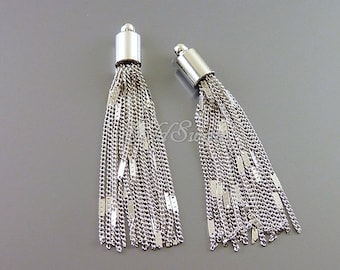 May include: Two silver chain tassel charms with a silver cap at the top. The tassels are made of multiple strands of silver chain.