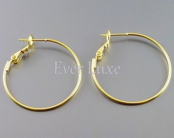 Puede incluir: Un par de pendientes de aro dorados con cierre de clip. Los pendientes son simples y elegantes, y serían una gran adición a cualquier colección de joyas.