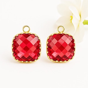 May include: A pair of gold-tone earrings with red square-shaped faceted glass stones.