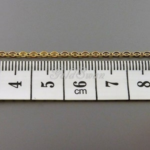May include: A gold chain measuring 6 cm in length, laid out on a white measuring tape.
