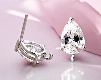 May include: A pair of silver teardrop-shaped earring findings with clear cubic zirconia stones. The findings have a loop on the side for attaching to a chain or other jewelry.