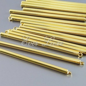 May include: A collection of shiny, gold-colored metal tubes with small loops at each end. The tubes are cylindrical and appear to be components for jewelry making or other crafts. The image is well-lit, highlighting the metallic sheen.