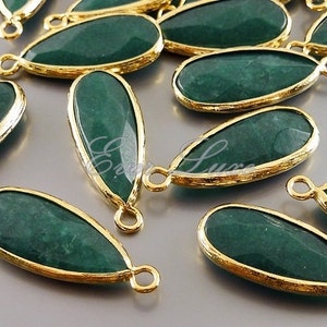 May include: A group of green gemstone teardrop pendants with gold-toned metal accents. The pendants have a smooth, polished finish and are perfect for jewelry making.