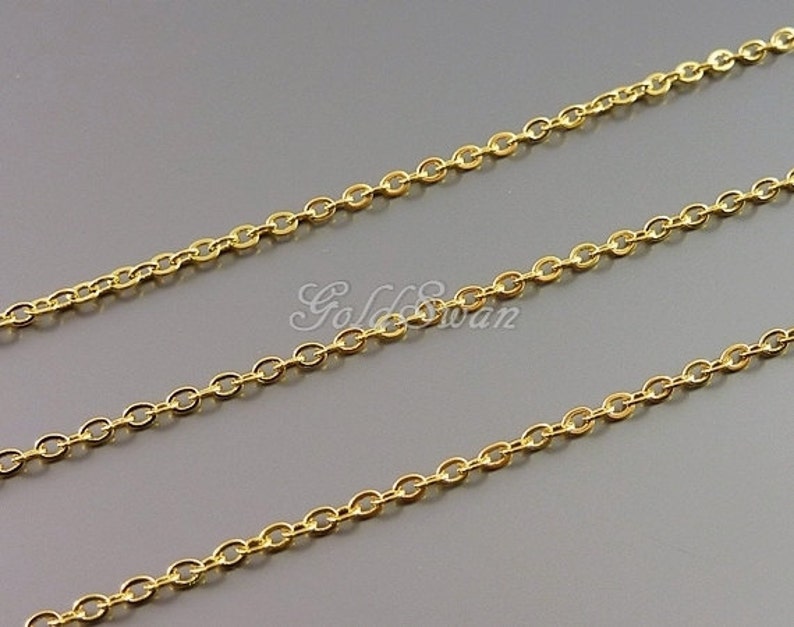 May include: A gold chain necklace with a delicate, oval-shaped link design. The chain is shown in three rows, showcasing its length and detail.