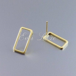 Könnte beinhalten: Ein Paar goldfarbene rechteckige Ohrringe. Die Ohrringe sind schlicht und minimalistisch.