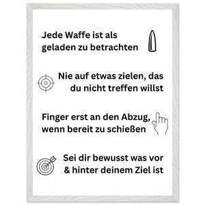 May include: A framed print with black text and illustrations on a white background. The text includes safety advice about firearms, such as treating every weapon as loaded and aiming carefully. The frame is white.