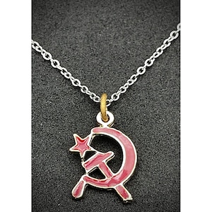 May include: A silver chain necklace with a red enamel pendant featuring a hammer and sickle with a gold star.