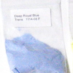 Puede incluir: Una pequeña bolsa de plástico transparente que contiene polvo azul real intenso. Una etiqueta blanca en la bolsa dice "Deep Royal Blue Trans 1114-08 F". El polvo es finamente molido y tiene un color azul pastel claro.