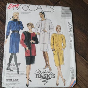 May include: A vintage McCall's sewing pattern envelope featuring illustrations of women's fashion basics. The envelope displays a blue dress, a black and red color block top, a white tunic, and a yellow dress. The text "Fashion Basics" is visible.
