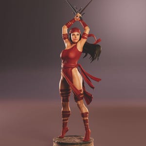 Może przedstawiać: Czerwono-czarna figurka akcji przedstawiająca postać kobiecą trzymającą dwa miecze w pozie bojowej. Figurka stoi na ceglanej podstawie.