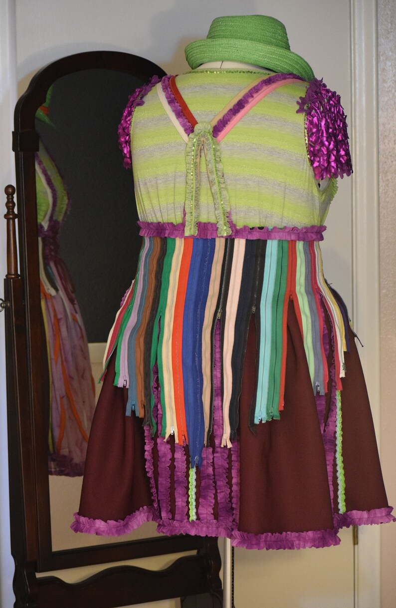 May include: A green and purple dress with a striped bodice and a skirt made of colorful zippers. The dress has a ruffled hem and a green hat.