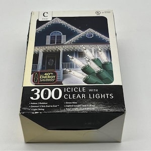May include: Box of 300 icicle lights with clear bulbs and green wire. The box features an image of a house decorated with the lights. The text on the box reads "300 Icicle with Clear Lights" and "40% Energy Savings". Lighted length is 6 m.