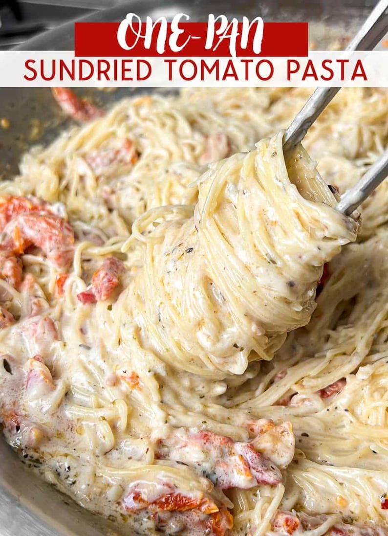 Puede incluir: Primer plano de pasta cremosa con tomates secos en una sart&eacute;n. La pasta se levanta con pinzas, mostrando la salsa y los ingredientes. El texto "ONE-PAN SUNDRIED TOMATO PASTA" se muestra en la parte superior.