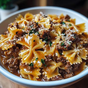 Könnte beinhalten: Eine weiße Schüssel gefüllt mit einer großen Portion Pasta mit Fleischsauce und mit geriebenem Käse und Petersilie bestreut.