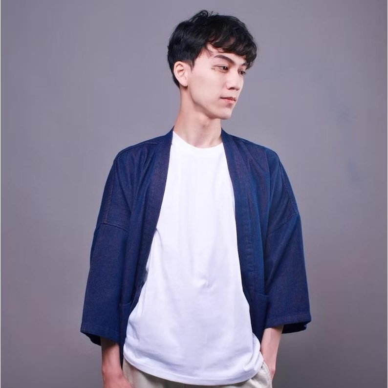May include: A navy blue cardigan with a relaxed fit and long sleeves. The cardigan is made of a lightweight fabric and has a simple design.