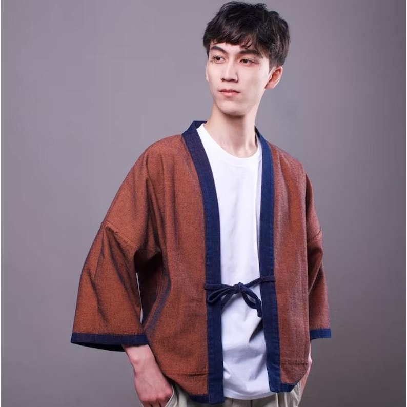 May include: A brown and blue cotton kimono with a tie closure. The kimono has a textured fabric and a dark blue trim.
