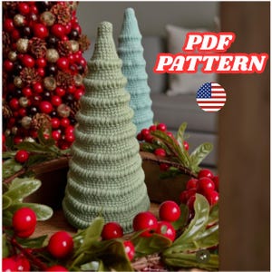 Può includere: Decorazioni per l'albero di Natale all'uncinetto nei toni del verde e del blu, con una ghirlanda di bacche rosse e verdi. L'immagine include il testo "PDF PATTERN" e una bandiera americana.