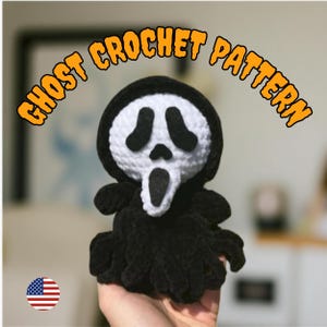 Könnte beinhalten: Handgemachte schwarz-weiße Häkel-Geisterpuppe mit dem ikonischen Scream-Masken-Design. Die Puppe hat eine schwarze Kapuze und einen schwarzen Körper, mit einem weißen Gesicht und schwarzen Augen- und Munddetails. Der Text "GHOST CROCHET PATTERN" ist darüber gewölbt.