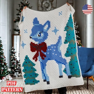 May include: A white crocheted blanket with a blue deer, red bow, blue stars, and green Christmas trees. The blanket has a pixelated design. The text "PDF PATTERN" is at the bottom.