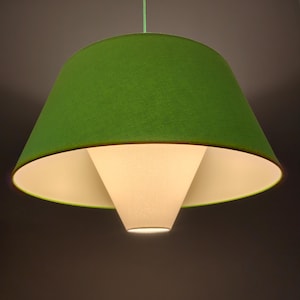 May include: A green fabric lampshade with a white inner shade. The lampshade is hanging from the ceiling.