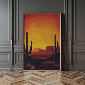 Puede incluir: Impresión artística enmarcada que representa un paisaje desértico al atardecer. La obra presenta dos altos cactus oscuros en primer plano, silueteados contra un cielo naranja y amarillo vibrante. Se ven montañas y vegetación desértica en el fondo.