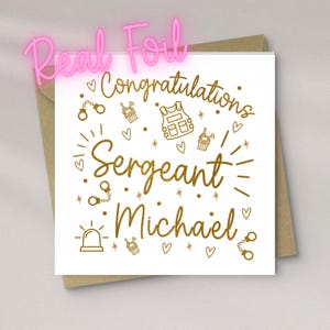 Könnte beinhalten: Weiße Glückwunschkarte mit goldfarbenem Text und Illustrationen, darunter Handschellen, Walkie-Talkies und eine kugelsichere Weste. Die Karte lautet "Herzlichen Glückwunsch Sergeant Michael". Ein rosa "Real Foil"-Schild befindet sich darüber.