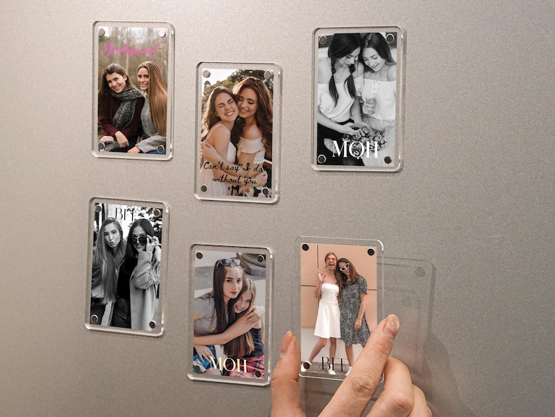 May include: Clear acrylic photo magnets with pictures of friends. Some magnets have text that says "MOM" and "BFF". One magnet has the text "Can't say I do without you". The magnets are on a gray surface.