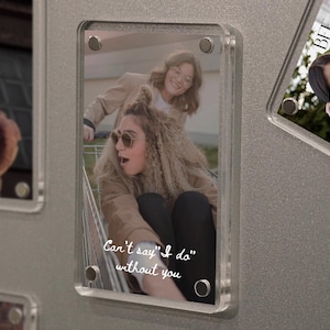 May include: Clear acrylic photo frame with a picture of two women, one in sunglasses and the other pushing a shopping cart. Text reads "Can't say "I do" without you."