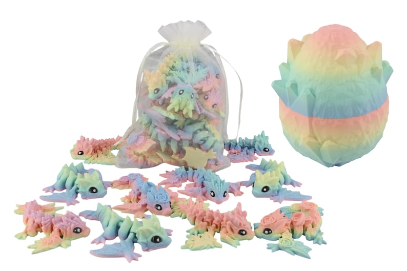May include: A selection of pastel-coloured dragon figurines and a large, matching egg-shaped sculpture. The dragons are in various poses, some inside a sheer bag. The egg is multi-layered with a textured surface, showcasing a rainbow of colours.