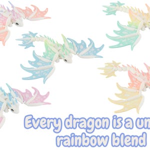May include: Several colorful dragon figurines with rainbow wings and bodies are displayed against a white background. The text "Every dragon is a unique rainbow blend" is also visible. The dragons are in shades of pink, blue, yellow, and green.