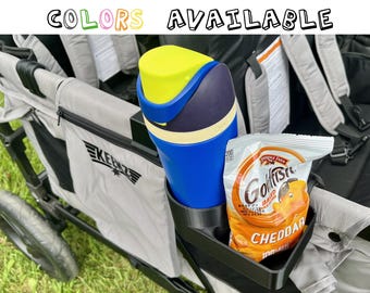 May include: A blue and yellow water bottle and a bag of cheddar Goldfish crackers sit in a black cup holder attached to a gray wagon. The text "COLORS AVAILABLE" is at the top.