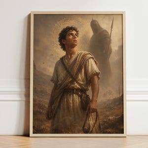 Puede incluir: Una lámina de arte enmarcada que muestra a una persona joven de pelo rizado con una túnica clara, sosteniendo una honda. Detrás, una gran figura sombría con armadura sostiene una lanza en un paisaje desértico con un halo circular brillante.