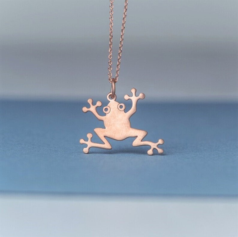 May include: A rose gold frog pendant necklace. The frog is a simple silhouette with no details.