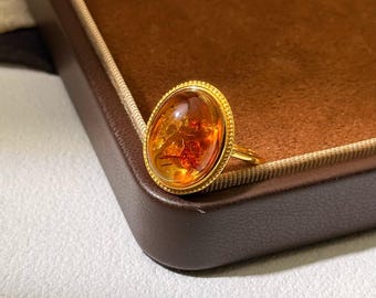 Anillo ovalado de ámbar en oro de 14 quilates con bisel vintage de cuentas y cabujón color coñac cálido.
