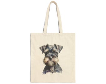 May include: Cream-colored tote bag featuring a watercolor portrait of a Schnauzer dog. The dog has a black and gray coat with a distinctive beard and eyebrows. The bag has two handles for carrying.