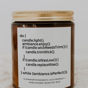 May include: A brown glass candle jar with a gold lid. The label reads "do { candle.light(); ambiance.enjoy(); if (candle.wickNeedsTrim()) { candle.trimWick(); } if (candle.isWaxLow()) { candle.replaceWax(); } } while (!ambiance.isPerfect()); GLOWWORTHYMOMENTS | ECO-FRIENDLY | HAND POURED VEGAN SOY WAX"