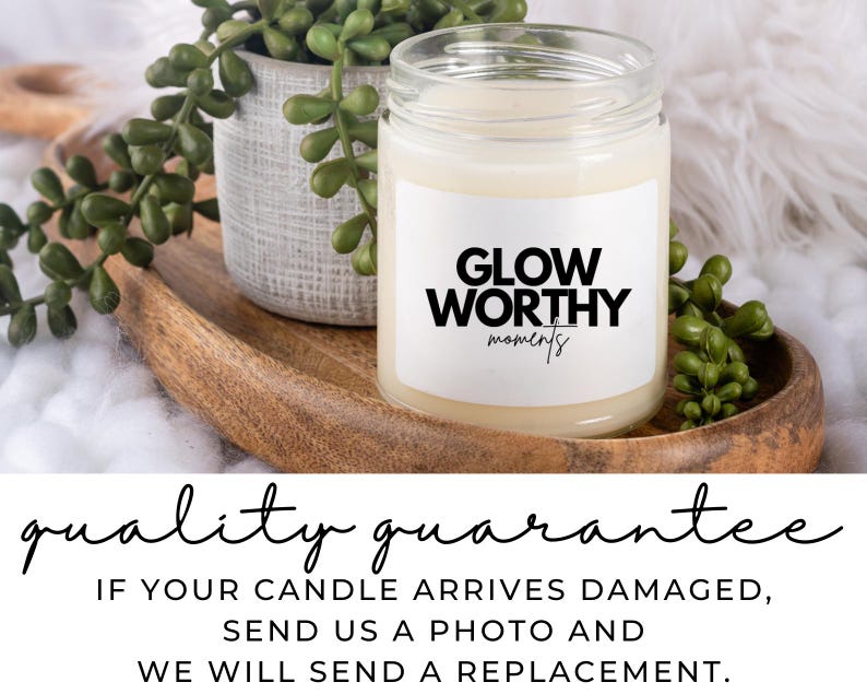 Op de afbeelding: Een witte kaars met een zwart label waarop "Glow Worthy moments" staat. De kaars staat op een houten dienblad met groene planten.