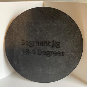 May include: A black circular jig with the text "Segment Jig 18-4 Degrees" printed on it.