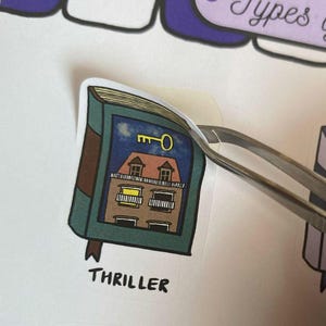 Thriller Book Sticker being peeled with a tweezer from the sticker sheet.