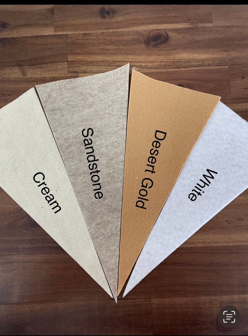 May include: Five fabric swatches in different shades of beige, cream, and white. The swatches are labeled "Cream", "Sandstone", "Desert Gold", and "White".