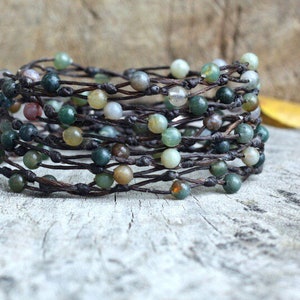 Könnte beinhalten: Ein mehrreihiges Armband aus braunem Leder und grünen, braunen und weißen Achatperlen.
