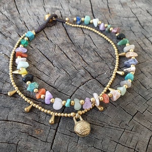 May include: A gold anklet with a charm and a double row of colourful gemstone beads.