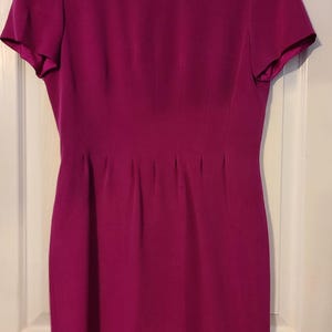 Peut inclure: Une robe magenta &agrave; manches courtes avec un corsage ajust&eacute; et une jupe l&eacute;g&egrave;rement &eacute;vas&eacute;e.