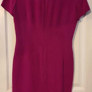 Peut inclure: Une robe magenta &agrave; manches courtes avec un design simple et une fermeture &eacute;clair dans le dos.