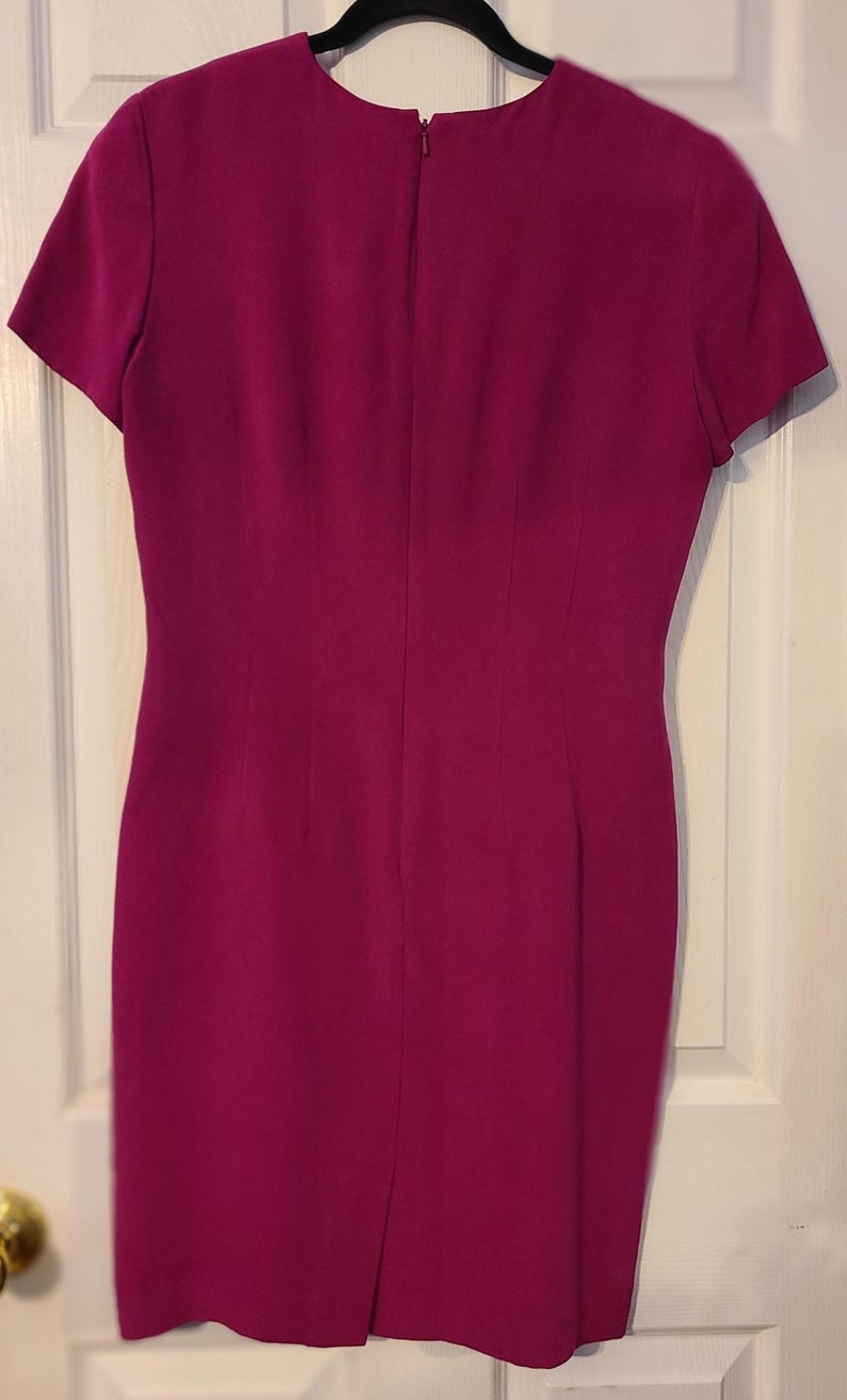 Peut inclure: Une robe magenta &agrave; manches courtes avec un design simple et une fermeture &eacute;clair dans le dos.