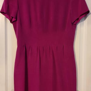 Peut inclure: Une robe magenta &agrave; manches courtes avec un corsage ajust&eacute; et une jupe l&eacute;g&egrave;rement &eacute;vas&eacute;e.