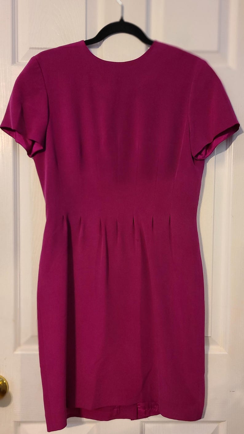 Peut inclure: Une robe magenta &agrave; manches courtes avec un corsage ajust&eacute; et une jupe l&eacute;g&egrave;rement &eacute;vas&eacute;e.